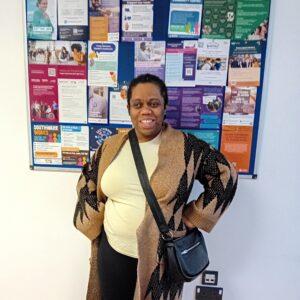 image showing woman stood proudly infront of noticeboard